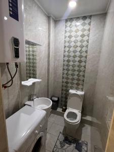 a small bathroom with a toilet and a sink at 3-room apartment at Isanova 1 in Bishkek