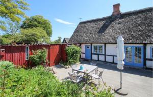 een patio met een tafel, een parasol en een huis bij Stunning Home In Sams With Wifi in Nordby