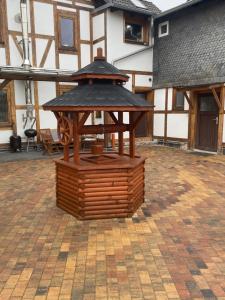 a wooden gazebo in the middle of a courtyard at Ferienwohnung sentio-comfortable Saalfeld in Saalfeld