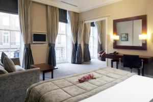 a hotel room with a large bed and a large window at Grange Beauchamp Hotel in London