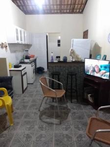 sala de estar con TV y cocina con perro en Refúgio sossego (casa de campo), en Camaçari