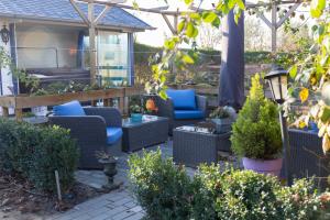 patio z wiklinowymi krzesłami i pergolą w obiekcie Alana Care Bed & Breakfast w mieście Tonden
