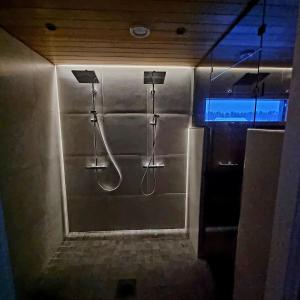 a bathroom with a shower with two hoses at Gorgeous Arctic Lodge in Rovaniemi