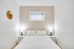 ein weißes Schlafzimmer mit einem Bett mit zwei Nachttischen in der Unterkunft Casa da Avó Maria in Arraiolos