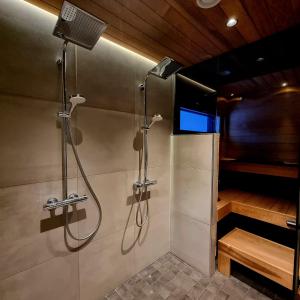 a bathroom with a shower and a tv in it at Gorgeous Arctic Lodge in Rovaniemi