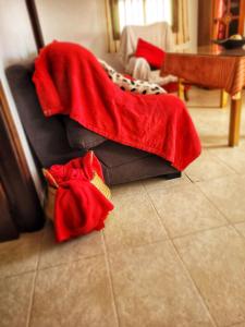 un sofá cubierto con una manta roja en el suelo en Apartamento La alberca 1, en Aracena