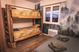 1 dormitorio con 2 literas y ventana en Maison de Rêve en Alsace - Chez Maïdala 3 étoiles, en Houssen