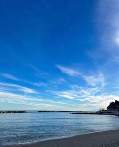 uma praia com um céu azul e o oceano em Dimora Villa Ricci em Pedaso