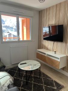 sala de estar con TV y mesa de centro en Superbe studio a Auron avec terrasse plein sud, en Auron