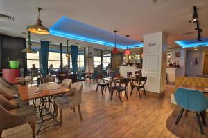Dodona ApartHotel in Prishtina في بريشتيني: مطعم فيه أرضيات خشبية وطاولات وكراسي