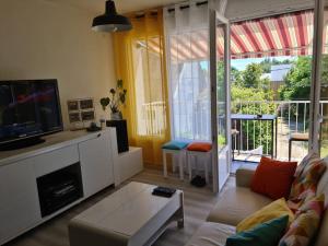 a living room with a couch and a tv at Superbe appartement en plein centre de Carnac in Carnac