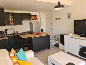 a living room with a couch and a kitchen at Superbe appartement en plein centre de Carnac in Carnac