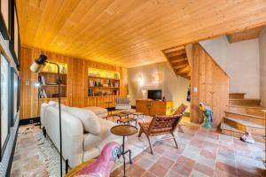 a living room with a white couch and wooden ceilings at Le 9 bis, Idéal pour un couple. in Le Bois-Plage-en-Ré