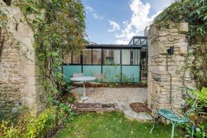 a garden with a table and chairs in a building at Le 9 bis, Idéal pour un couple. in Le Bois-Plage-en-Ré