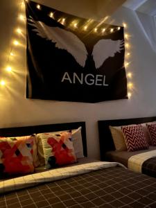 una habitación con 2 camas y un cartel con un ángel en la pared en Room2#IG theme Bargainous#Shared Bathroom#4pax#2min Kek Lok Si en Ayer Itam