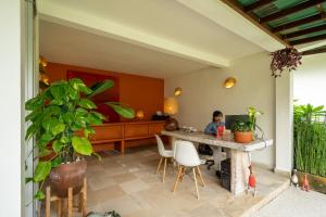 una persona sentada en una mesa en una habitación en Rouge - Villas & Spa, en Ubud