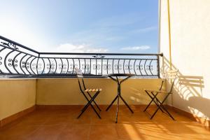 a balcony with a table and chairs on it at Dodona ApartHotel in Prishtina in Pristina