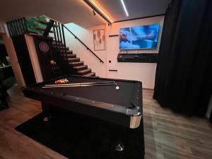 a room with a pool table and a tv at Aux Secrets De Lora, Chambre de charme VIP in Verviers