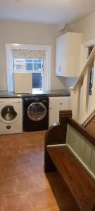 a kitchen with a washing machine and a washer at Country Mansion - Private Annexe in Llanwrda