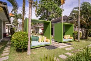 una casa verde con una piscina in un cortile di Rouge - Villas Ubud ad Ubud