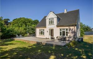 een klein wit huis met een terras in de tuin bij Cozy Home In Anholt With Kitchen in Anholt