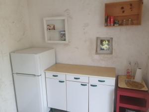 uma cozinha com armários brancos e um frigorífico branco em Gîte Les Jardins de Terrefort em Saumur