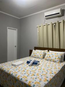a bedroom with a bed with a yellow and blue blanket at Pousada Sertaneja in Canindé de São Francisco