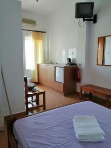 sypialnia z niebieskim łóżkiem i kuchnią w obiekcie RODON PIGANOUSA STUDIO in Spilia Leros w mieście Panteli