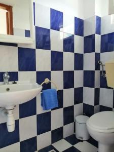 a blue and white bathroom with a sink and a toilet at RODON PIGANOUSA STUDIO in Spilia Leros in Panteli