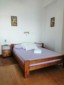 a wooden bed in a room with a night stand at RODON PIGANOUSA STUDIO in Spilia Leros in Panteli