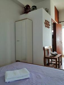 a bedroom with a bed and a cabinet and a chair at RODON PIGANOUSA STUDIO in Spilia Leros in Panteli