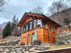a log cabin with a stone wall at Baita del noce in Mollia