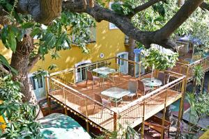 une terrasse avec des chaises, des tables et un arbre dans l'établissement Hotel Villa Des Gouverneurs, à Pondichéry