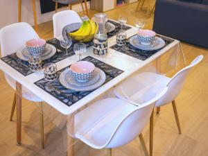 una mesa de comedor con platos y vasos. en LE CONCORDE-WIFI-Clim-Parking-3étoiles-OcKeys, en Bram