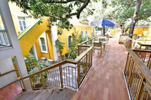 uma varanda com uma mesa e um guarda-chuva azul em Hotel Villa Des Gouverneurs em Pondicherry