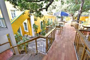 a balcony with a table and a blue umbrella at Hotel Villa Des Gouverneurs in Puducherry