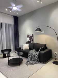 uma sala de estar com um sofá preto e uma mesa em 5 min Sunway Lagoon PJ KL Cosy Stylish Suite Big Pool em Petaling Jaya