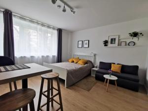 a bedroom with a bed and a couch and a table at Studio apartman Mirta in Varaždin