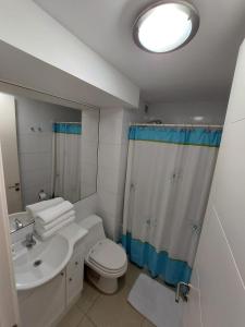 a bathroom with a white toilet and a sink at Costa Azul la Herradura in Coquimbo