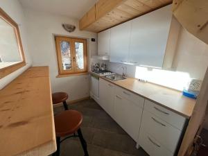 m&m cabins في Gordona: مطبخ بدولاب بيضاء وقمة كونتر خشبي