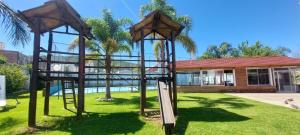 un parque infantil frente a un edificio en Hotel El Cid, en Villa Carlos Paz