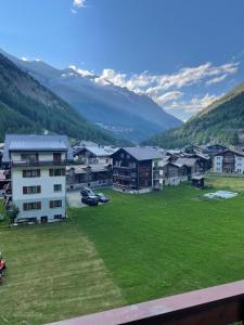 un gruppo di edifici in un campo con montagne di Haus Antares a Saas-Almagell