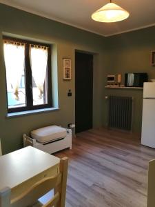 a living room with a white refrigerator and a table at La Casetta in San Maurizio Canavese