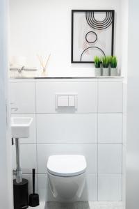a white bathroom with a toilet and a sink at STILVOLLES APARTMENT in Vienna
