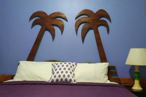 ein Schlafzimmer mit einem Bett mit zwei Palmen an der Wand in der Unterkunft Entire 6-Bedroom Villa Free parking with Fast Wifi in Discovery Bay