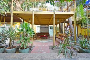 Hotel Villa Des Gouverneurs في بونديتْشيري: منزل به فناء به نباتات و بيانو