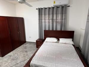 - une chambre avec un grand lit et une fenêtre dans l'établissement Inviting 3-Bed House in Accra, à Accra
