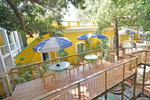 una terraza con mesas y sombrillas en un edificio en Hotel Villa Des Gouverneurs en Pondicherry