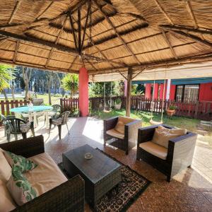 eine Terrasse mit Gartenmöbeln und einem großen Sonnenschirm in der Unterkunft Hotel y Casa de Campo Oasis Campero Ezeiza -San Vicente in San Vicente