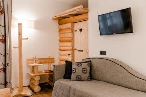 a living room with a couch and a flat screen tv at Hotel Kirchenwirt in Dobbiaco